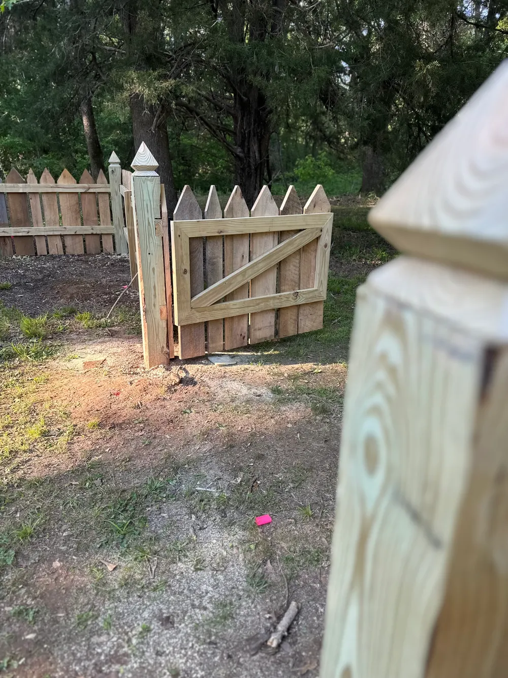 Custom braced cypress picket gate with hand-cut pointed pickets